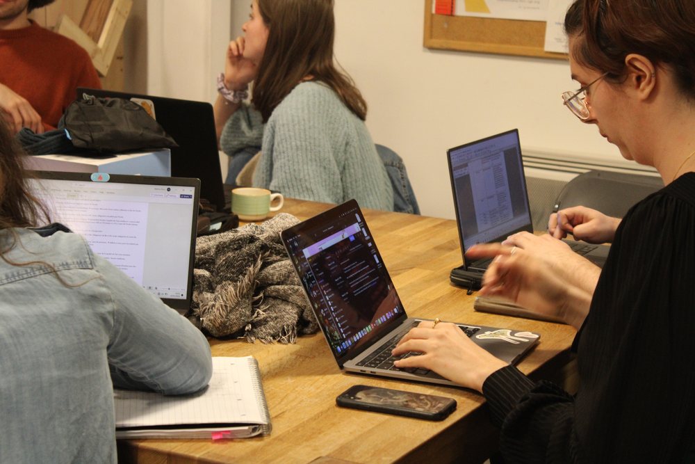 Participantes et participants de l’atelier d’écriture rédigent leurs textes autour d’une grande table